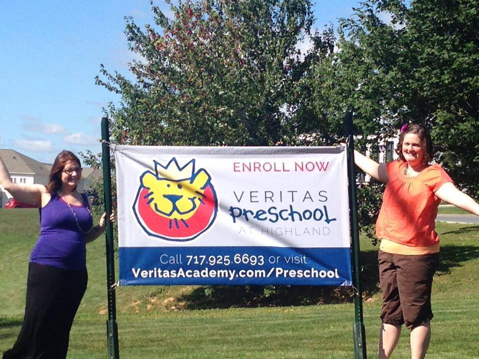 Teachers standing at a sign